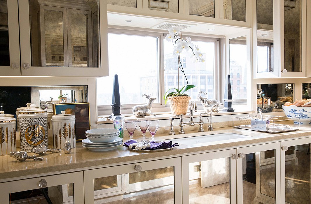 Panels of antique mirror make the kitchen sparkle. “I wanted my kitchen to feel like a big bar,” Alex says.
